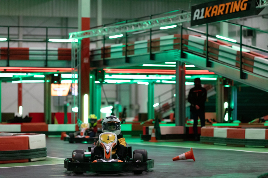 Gokart spalinowy w kontrolowanym poślizgu bocznym na torze kartingowym - tylne koła w drifcie, ślady opon na asfalcie